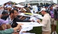 Rory McIlroy of Northern Ireland signs autographs for fans during a practice round.
