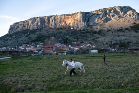 Kostas and Fotini walk with the family’s mare in front of the prehistoric cave of Theopetra village.