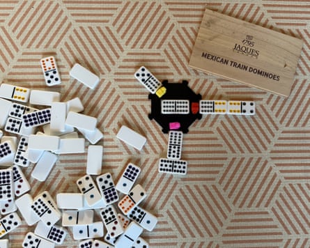 Dominoes scattered beside a Mexican Train game set, tested as a gift for nine-year-olds