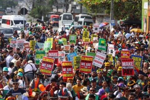 Pessoas seguram cartazes com os dizeres "emergência climática, nós somos a resposta".