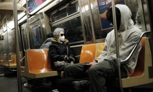 A person wearing a face mask rides the subway in New York City.
