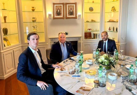 The three men sitting at an elaborate dining table