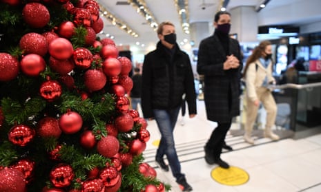 Masked shoppers next to a Christmas tree
