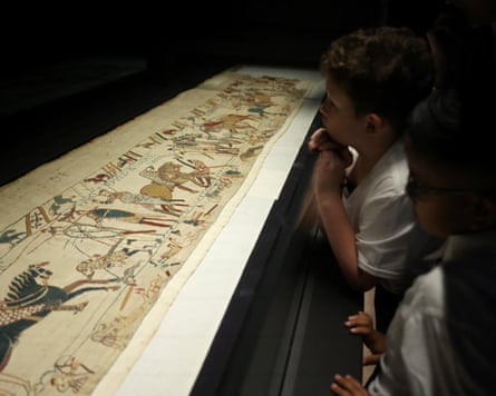 Schoolchildren looking at part of the tapestry in a museum.