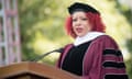 woman in academic robes speaks at lectern