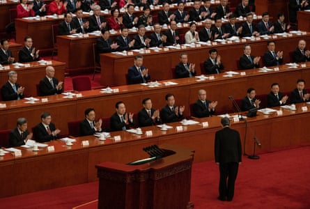 Chinese President Xi Jinping, centre, and other senior members of the government applaud inside the Great Hall of the People