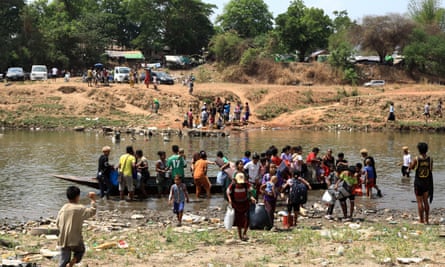 Myanmar villagers cross the Moei river at the Thai-Myanmar border district of Mae Sot, fleeing heavy fighting between the rebels and the junta