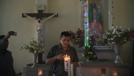 Cruz Bautista, uncle of Benjamin and patron of Saint Salvador, lights up a candle in the church for the celebration.