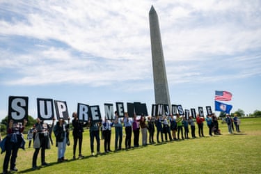people hold letter signs that spell ‘supreme injustice’