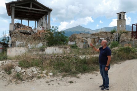 Giorgio Cortellesi pointing at a destroyed building