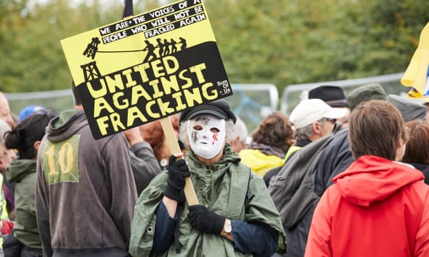 A masked protester holds an anti-fracking sign in Little Plumpton, Lancashire