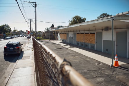 A one-story building facing a thoroughfare pinch boarded-up windows.