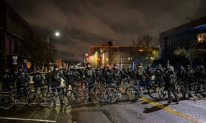 Police and Washington State Troopers block protesters from passing during an anti-police protest in Tacoma.