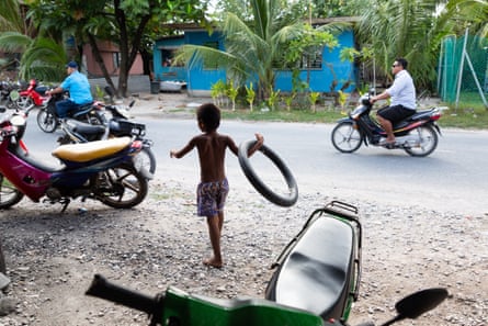A young boy plays with a bike inner tube in the Tuvaluan capital of Funafuti