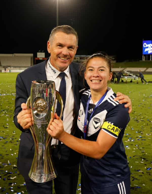 Melbourne Victory coach Jeff Hopkins with captain Angela Beard and the 2020-21 championship trophy.