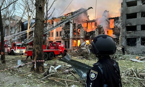 Camiones de bomberos en el sitio de un bloque de apartamentos en llamas después de ser alcanzado por un sitio de misiles rusos.