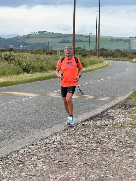 James running on an empty road near fields