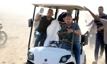 Palestinians transporting a captured Israeli civilian from Kibbutz Kfar Aza into Gaza on Saturday.