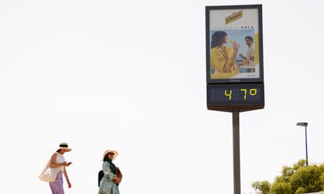 Women near a thermometer displaying 47C in Seville, Spain on 11 June.