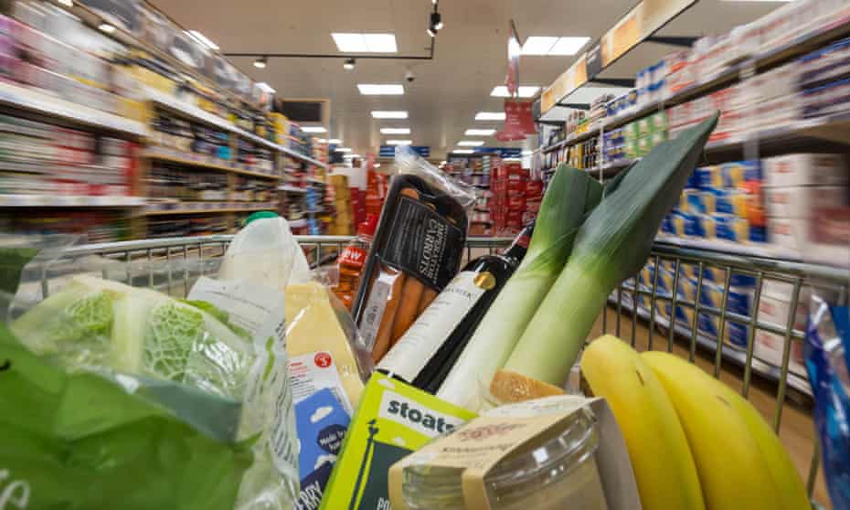 A shopping trolley with groceries is pushed around a supermarket