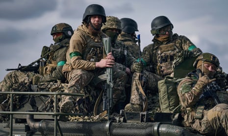 Ukrainian soldiers ride atop an APC on the frontline in Bakhmut, Donetsk region.