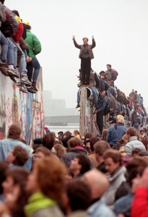 Berliners celebrate on top of the wall as East Germans flood through into West Berlin at Potsdamer Platz.
