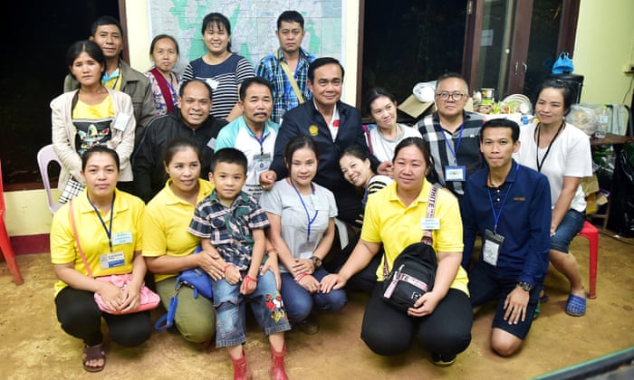Thailand’s Prime Minister Prayuth Chan-ocha poses with relatives of boys trapped in the flooded Tham Luang cave