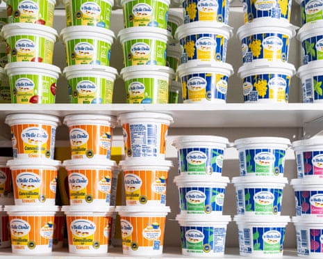 Rows of cancoillotte in different coloured pots on a shelf