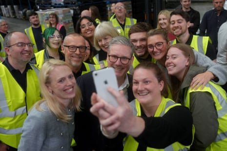 Keir Starmer taking a selfie with workers during a visit to Global Brands in Claycross, Chesterfield, Derbyshire.
