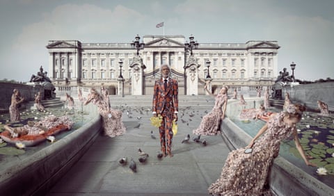 An Indigenous man in a floral suit holding flowers and a bag of chips in centre frame, with a white woman in a floral dress replicated in various poses surrounding him, on a path bordered by fountains facing a Imperial-feeling. The photograph is largely desaturated