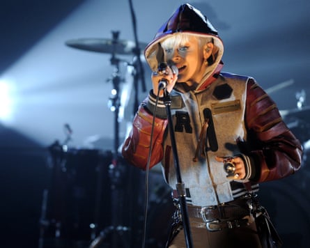 Robyn on stage in a hooded top with a microphone.