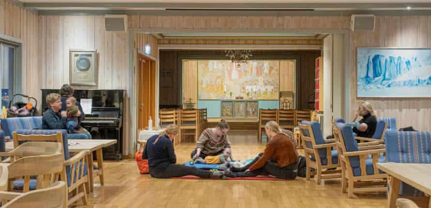 Circle of parents and children on the floor near the piano