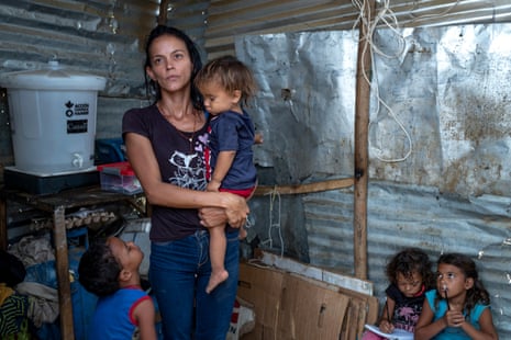 Elaine Rojas, 27, and her four children in the shack in La Pista where they live with her husband and 2,000 other Venezuelan families.