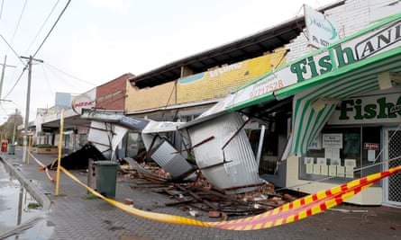 Debris covers the pavement after strong winds damaged shopfronts in Perth on Monday.