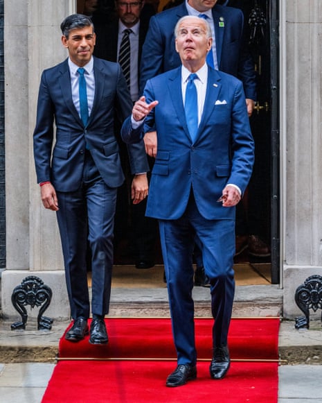 Joe Biden appears to be checking the weather as he leaves 10 Downing Street after visiting Rishi Sunak.