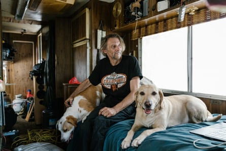 Chris Eakin with his dogs Mimi, left, and Blondie, right, inside his RV parked on Toland Avenue in San Francisco, California.