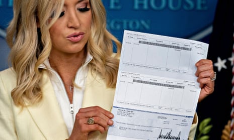 White House press secretary Kayleigh McEnany, holds up a Donald Trump cheque, to be donated to the US Department of Health and Human Services. 