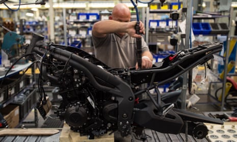 Employees assemble motorcycles on the assembly line at the Triumph Motorcycles factory in Hinckley