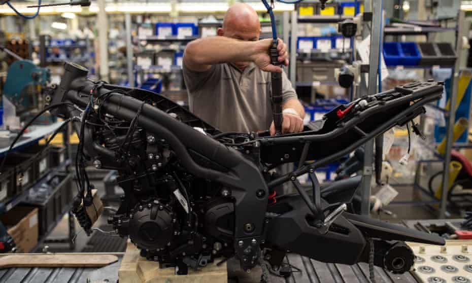 A worker assembles a motorcycle on the Triumph factory line in Hinckley, England