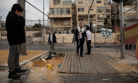 An Orthodox Jew passes the scene of a mass shooting in Neve Yaakov.