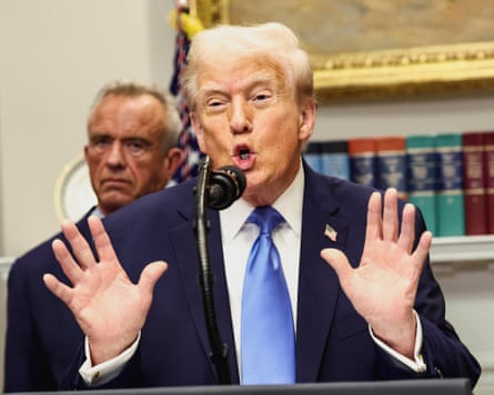 Donald Trump speaks into the microphone while holding up his hands