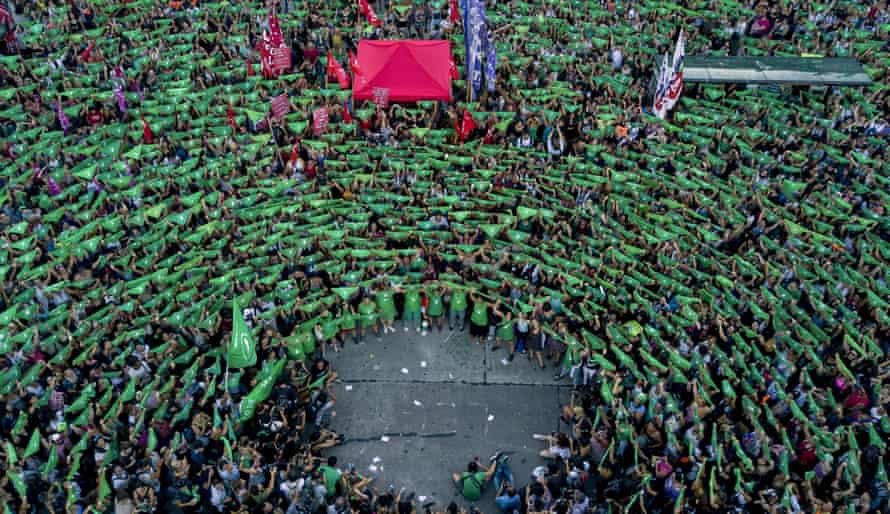 A mass of protesters appears like a green swirl from above 
