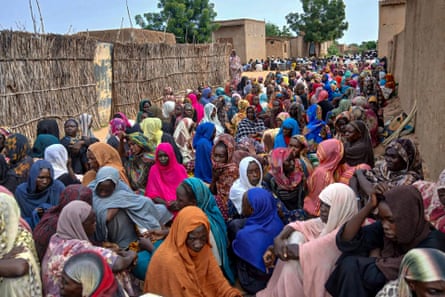 People gather to wait for food aid in El Fasher.