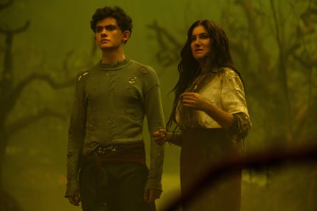 A young man with curly dark hair and an older woman with long dark hair, in what looks like a wood