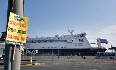 A P&O ferry in Northern Ireland. A placard atached to a nearby post reads: 'STOP THE P&O JOBS CARVE UP'