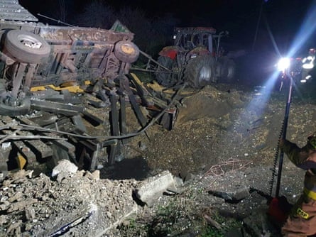 A damaged vehicle lies next to a crater formed at the site of an explosion in Przewodów, a village in eastern Poland near the border with Ukraine.