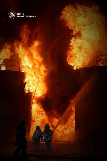 Two firefighters battle huge flames.