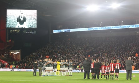 Manchester United and Sheffield United players observe a minute of applause for Bobby Charlton.
