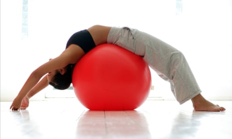Young woman stretching on exercise ball