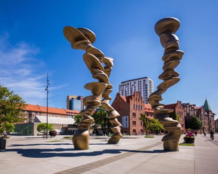 Tall sculptures consisting of smooth stone-like shapes stacked on top of each other and curving in parts